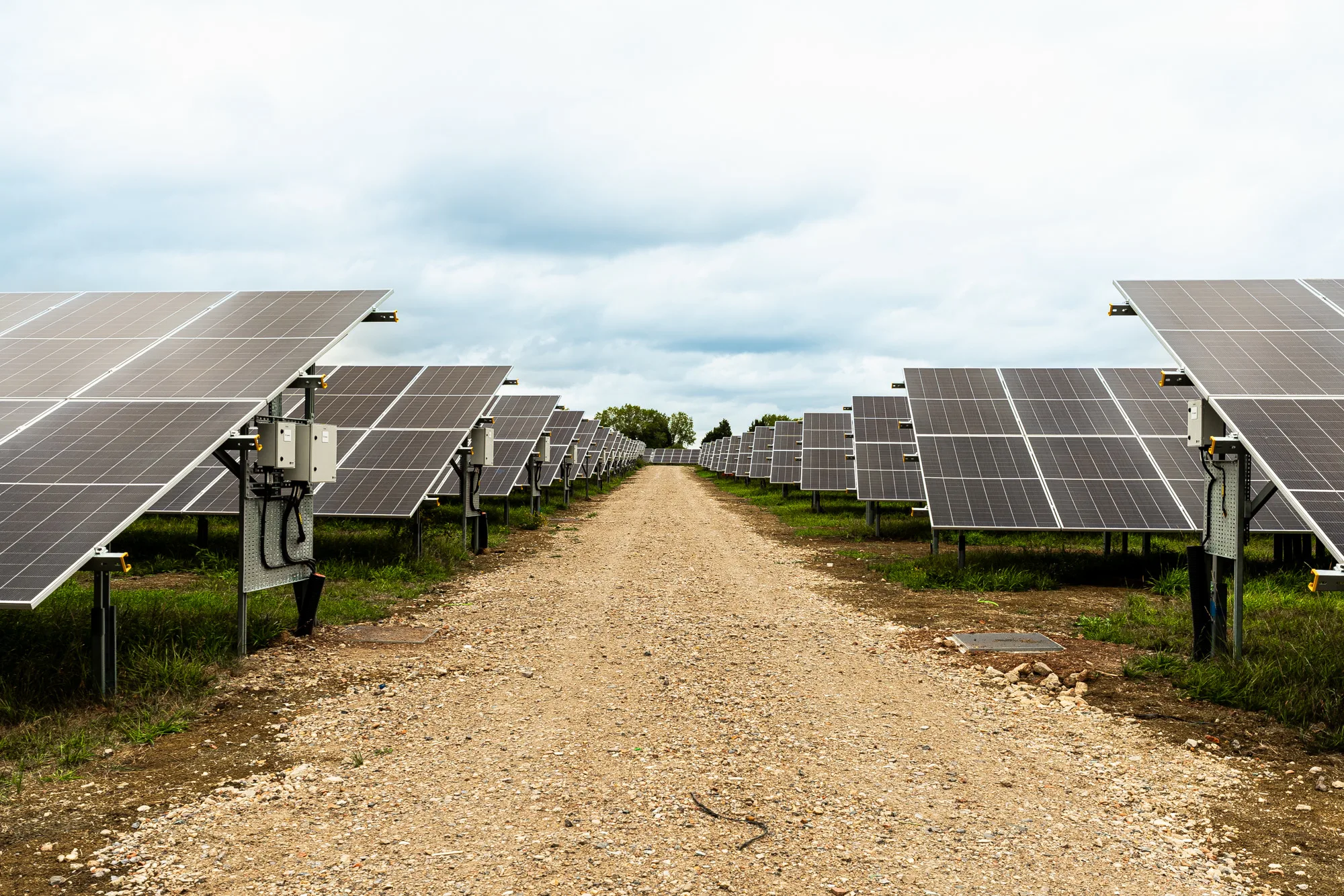 Rows of solar panels beside a gravel access track