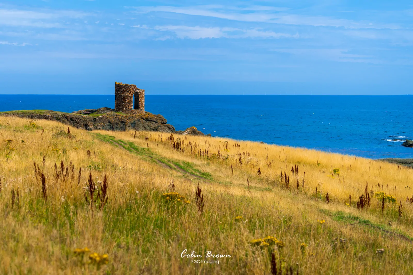 Ruined stone tower on a coastal headland overlooking the sea