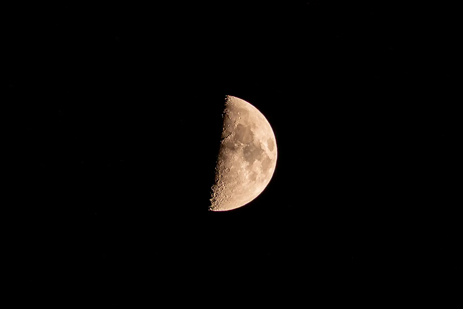 Close-up of a half-illuminated crescent moon against a black sky